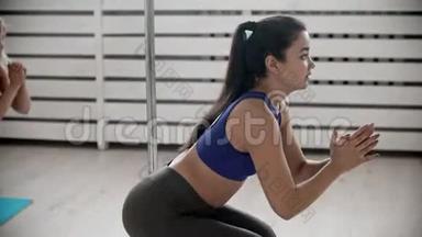 年轻女子训练师在健身训练时蹲着